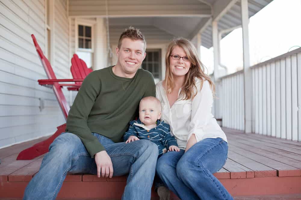 Relaxing couple and infant on a home veranda happy with the work done by Smartway Builders.